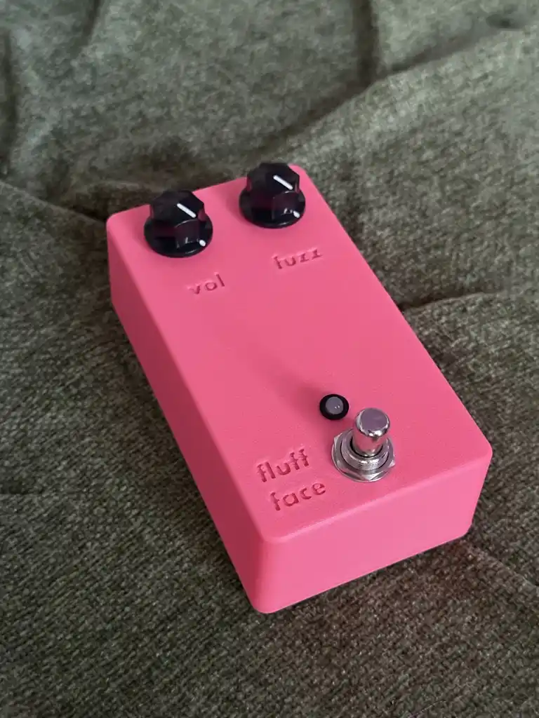 picture of pink electronic guitar pedal with some knobs